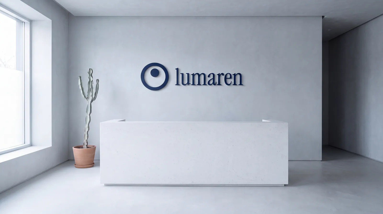 A white reception desk at the fictional Lumaren clinic: on the grey wall the navy logo, a ring with a dot and the name in lowercase, beside a potted cactus
