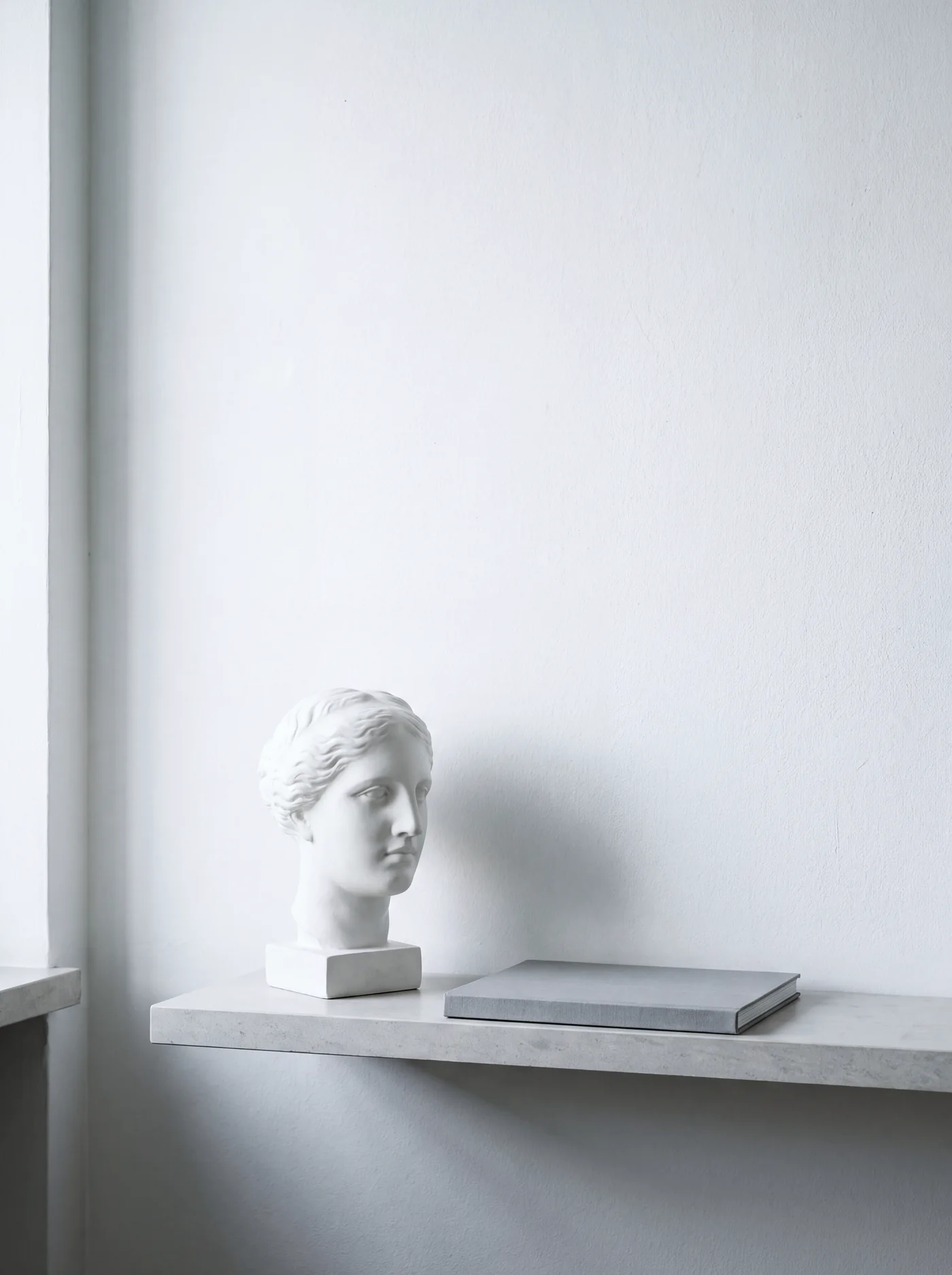 A plaster study of a face on a stone shelf