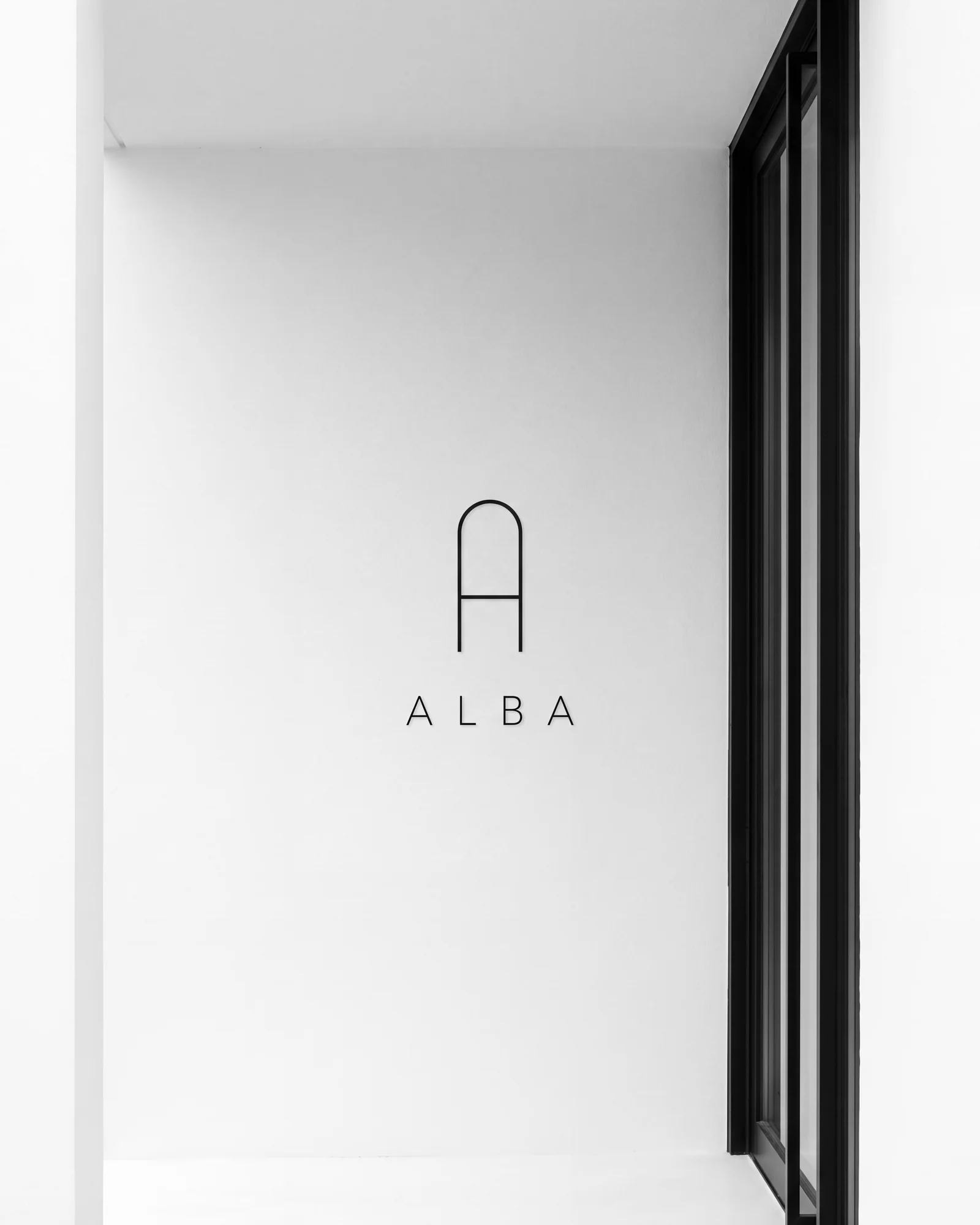 The ALBA lockup on the white wall of the entrance