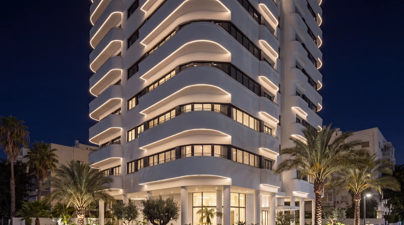 ALBA at night with light lines under every curved balcony